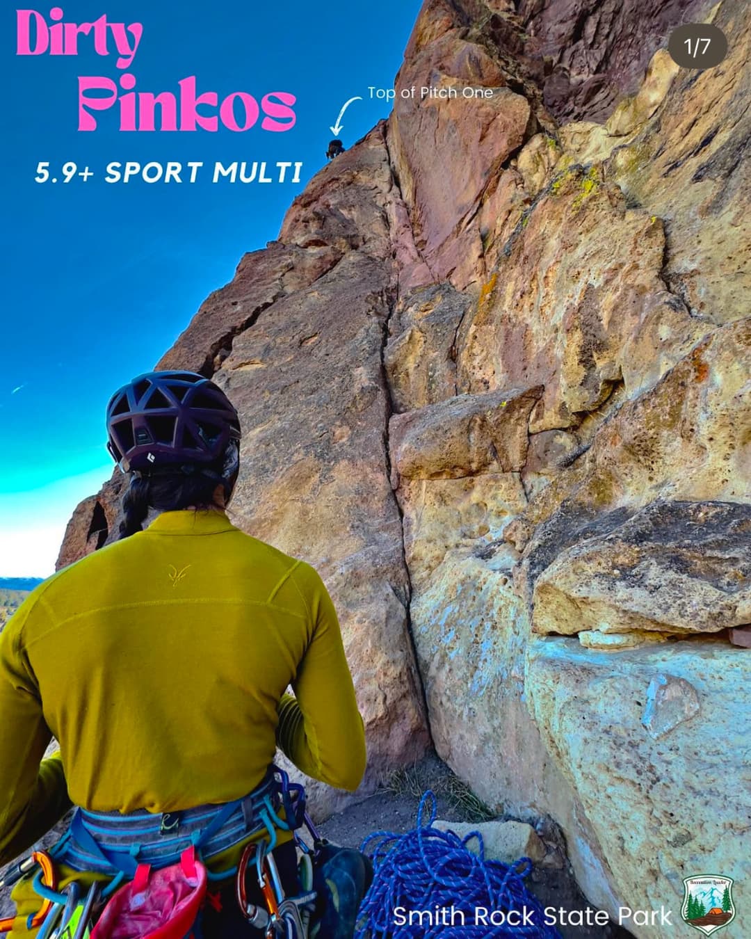 Climber in yellow shirt and helmet at base of rock face, preparing for ascent at Smith Rock State Park.